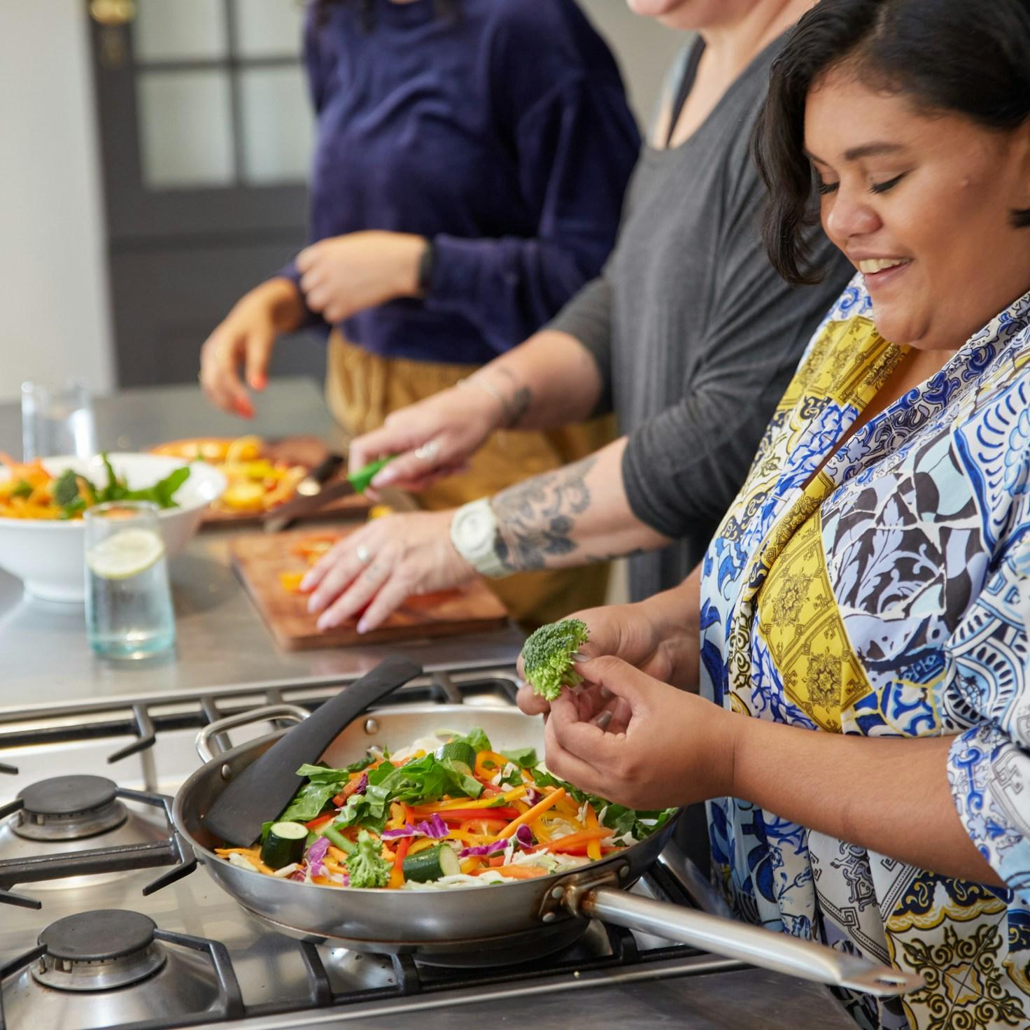 Community members collaborating in a modern kitchen space, sharing recipes and cooking techniques
